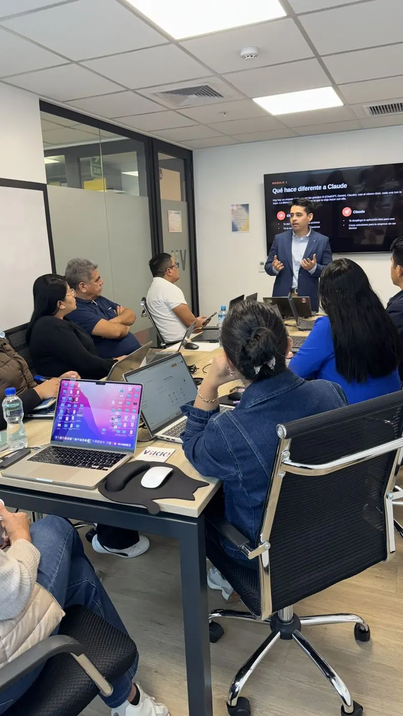 Kevin De la Zota dictando un curso de IA frente a un grupo con laptops